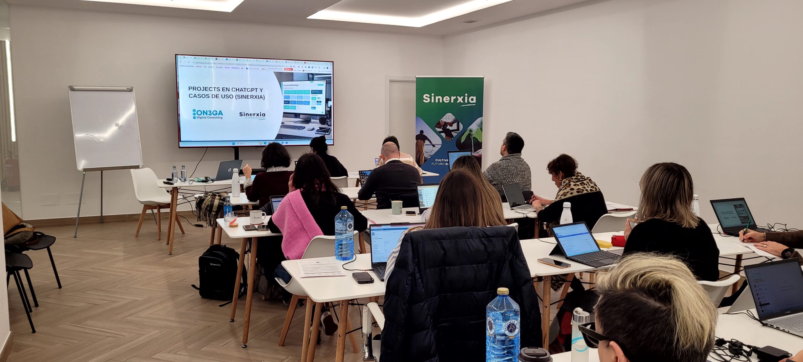 Aula del taller Sinerxia con una docena de alumnos con portátiles siguiendo una sesión práctica de ChatGPT